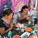 2 women decorate skulls at a table covered in crafting material